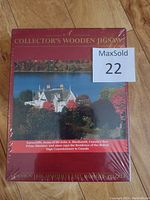 Front of a sealed burgundy box of a wooden jigsaw puzzle titled 'Collector's Wooden Jigsaw' with image of Earnscliffe house.