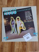 Front of Miami Vice vinyl LP jacket showing two men with neon light letters spelling Miami Vice.