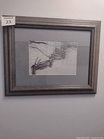 Framed print of Robert Bateman with snow-covered wooden fence and bare trees in winter scene, shown hanging on a white wall.