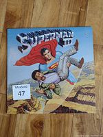 Front cover of Superman III vinyl LP showing Superman carrying a man over a canyon.
