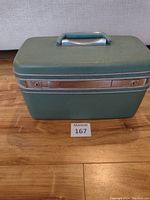 Front view of the turquoise vintage Samsonite hard-shell luggage case showing metal trim and front locks.