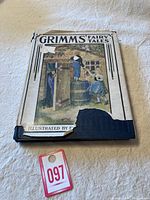 Front cover of 1925 Grimms' Fairy Tales book showing illustrated children and damage at bottom right edge.