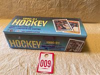 Factory sealed 1990-91 OPC hockey card set box with blue and green gradient background, showing images of hockey cards on the box.