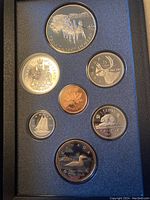 Top view of seven Canadian coins from 1992 proof set placed in black foam tray showing various denominations and designs, including the large double dollar coin.