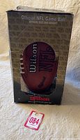 Football in original box showing Wilson branding and NFL official game ball markings.