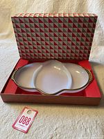 Overview of milk glass divided dish in original patterned box with red interior lining and a tag label