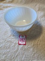 Single white milk glass swirled bowl showing inside and general shape.