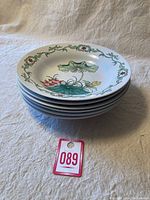 Stack of 6 hand painted soup bowls showing their decorative designs and size