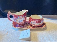 Set viewed from front showing cream and sugar bowl on tray with floral chintz pattern and visible crazing.