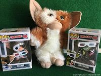 Three Gremlins-themed items: Funko Pop Gizmo figure in box, Funko Pop Gremlin figure in box, plush Gizmo toy.