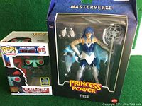 Two boxed figures side by side, showing both Funko Pop and Princess Power lines in original packaging.
