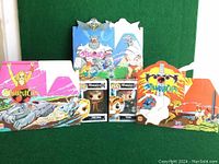 Wide shot showing 2 Funko Pop in box and 3 vintage Thundercats-themed fast food kids meal cardboard boxes in various colors and designs.