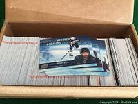 Photo of a cardboard box filled with stacked Tim Horton hockey cards and a small stack of cards on top, including Blake Wheeler card.