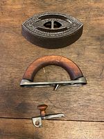 Detailed view of all parts including detached wooden handle, decorative iron base, and metal latch component