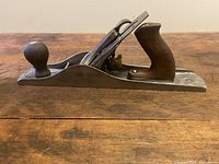 Side view of the Stanley Bailey corrugated No.5 hand plane showing wooden front knob, rear tote, and metal body with blade.
