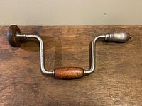 Top-down view of the antique Stanley No.966 hand drill showing the full metal brace and wooden turning knob.