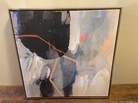 Front view of the framed abstract canvas painting showing the colorful artwork with black, white, gray, and orange.