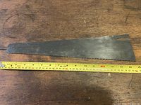 Full view of the 16 inch hand saw blade showing length, taper, teeth along edge, and slot near handle end