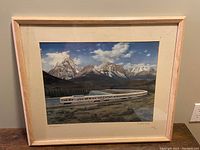 Frontal view of framed vintage Canadian Pacific passenger train painting showing mountain backdrop and train.