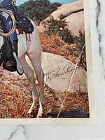 Close-up showing the signature 'The Lone Ranger' printed on the bottom right of the photo print and visible creasing and fold lines.