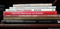 Stack of 7 calligraphy books showing spines with titles and authors.