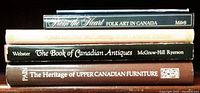 Five hardcover books stacked showing titles related to Canadian antiques and heritage.