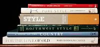 Seven stacked books with titles visible, focusing on regional and country style decor and design.