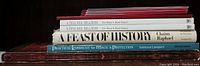 Spine view showing five books including 'A Passover Haggadah' by Elie Wiesel and Mark Podwal, 'A Feast of History' by Chaim Raphael, and 'Practical Kabbalah for Magic & Protection' by Vanessa Lampert.