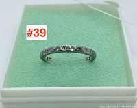 Full view of the white gold diamond ring on light green foam in a protective transparent box.