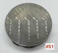 Top view of the circular Art Deco sterling silver compact, showing detailed geometric pattern on lid.