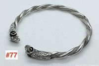 Full view of the sterling silver twisted rope bangle with ram heads, showing the open cuff style and detailed end terminals.