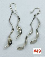 Front view of both earrings showing twisted sculptural form and fishhook wires.