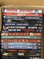 Top view of DVD movie spines including Fever Pitch, Stick It, Abduction, and others.