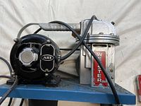 Top side view of air compressor showing the 'Western' labeled compressor housing with attached black motor labeled 'AEI'. Electrical wires attached.