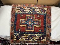 Full view of square antique Persian saddlebag pillow textile showing central geometric medallion and outer borders.