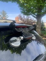 Black plastic kayak loading device mounted on car roof with two silver suction cups and Malone branding visible.