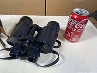 Front left view of Pentax Universe binoculars next to a soda can for scale.
