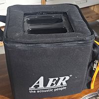 Soft black fabric carrying bag with zipper, AER logo and padded top openings visible