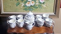 Full view of Churchill China tea set including cups, saucers, creamers, and sugar bowls arranged on wooden surface.