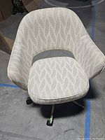 Front and top view of office chair showing leaf pattern upholstery and curved armrests