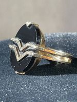 Front view showing oval black onyx and gold chevron motif