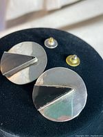 Front angled view of the silver and onyx Art Deco earrings showing circular shape with triangular black onyx insets and post backs.