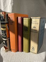 Five hardcover Upton Sinclair books lined up side by side showing spines and front covers, colors include black, orange, red, olive, white, and blue.