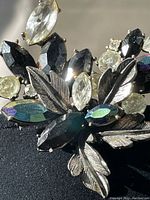 Close-up front angle showing brooch stones and silver-tone metal leaf elements