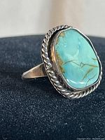 Close-up angled photo of the vintage silver ring showing the turquoise stone and rope edging from the side