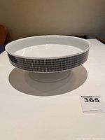 Side view of white pedestal bowl showing black geometric Medallion Onyx pattern around outer rim and pedestal base.