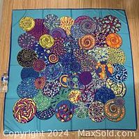 Full view of scarf laid flat showing full circle pattern design and background