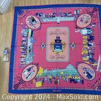 Top-down view of entire scarf laid flat on the floor showing overall color and design including the central perfume bottle and surrounding illustrations.