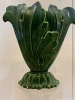 Front view of vintage green ceramic botanical vase, showing overall shape and design.