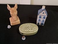 Three small liquor bottles: Dutch house, deer head, and Edinburgh Castle shape with respective stoppers.